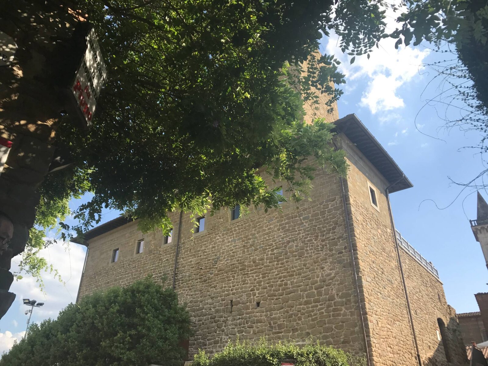 A stone tower under wisteria.